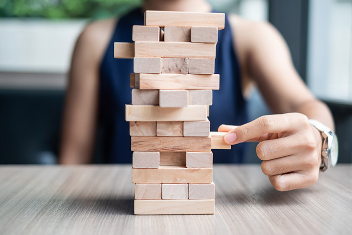 The One Critical Question Investors Forget to Ask When Shopping for Rentals Businesswoman hand placing or pulling wooden block on the tower. Business planning, Risk Management, Solution and strategy Concepts