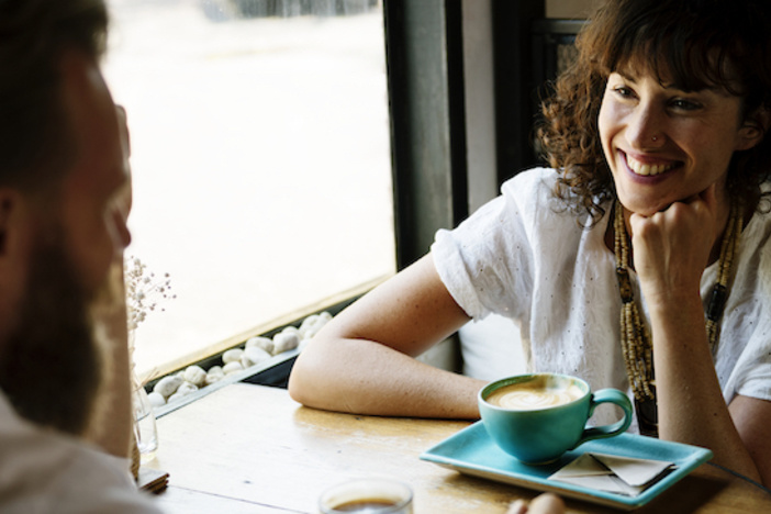 How to Use the DISC Profile to Communicate Effectively in Business two people sitting in a cafe at a table drinking coffee smiling