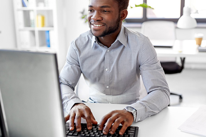 5 Ways to Use Facebook in Favor of Your Real Estate Investing Business man sitting at desk working on a computer
