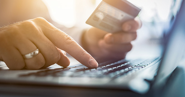 3 Reasons NOT to Buy an LLC Online Hands holding credit card and using laptop. Online payment and shopping concepts.