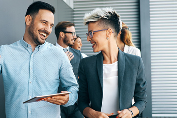 Pros & Cons of Entrepreneurship: Is It Right for You? business people walking, talking and smiling in office hallway