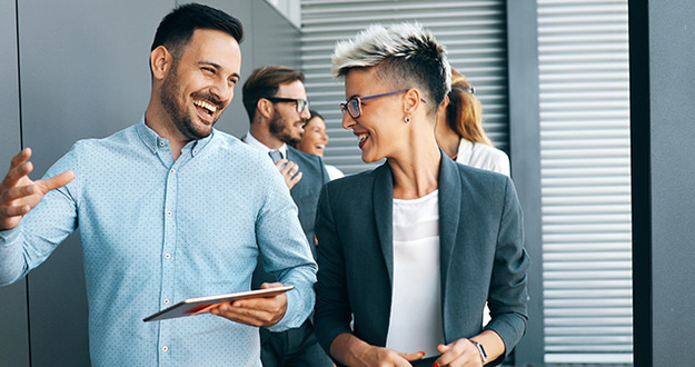 The 40-Something’s Guide to Start Investing in Real Estate business people walking, talking and smiling in office hallway