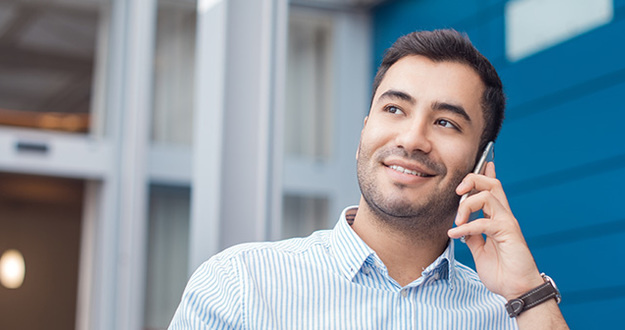 How We Found an Extra $400K on Two Properties Happy young man on phone, indoors - inside. Close up of businessman talking on mobile phone - smartphone. Comunicative friendly hispanic man