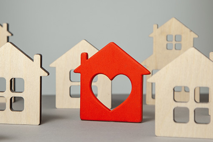 How to Pick the Perfect Property to Flip (& Maximize Your Profits!) natural color wooden house cutouts with one painted red with a heart cutout added
