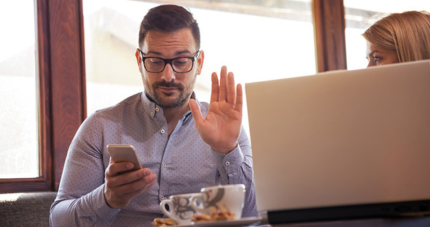 Top 3 Reasons You Should Never Invest in Real Estate A handsome young businessman tries to call the boss over the phone while sitting with his colleague in front of a laptop.