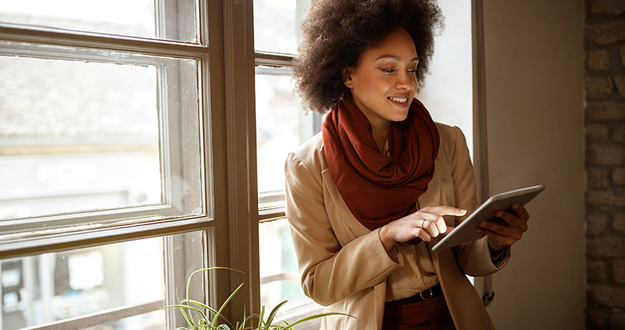 3 Types of Motivated Sellers (& How to Win Deals By Solving Their Problems!) Young Afro-American woman near window on workplace taking information from ipad
