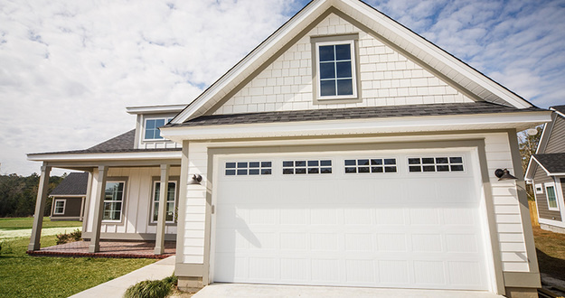 Is Building an Accessory Dwelling Unit (ADU) a Worthwhile Investment? home with white siding and two-car garage with room above