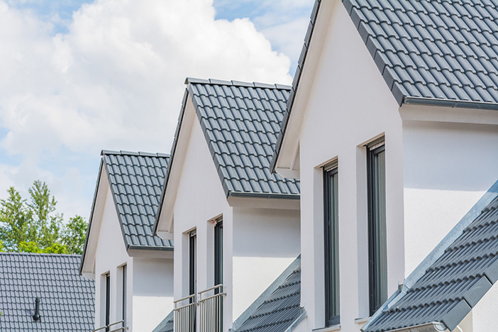 8 Ways to Identify the Best Places to Buy Rental Property close up view of upper level windows and roofs on four row homes
