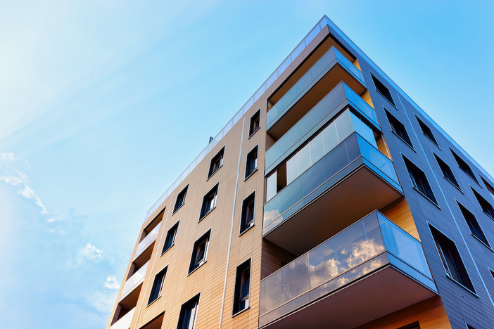 5 Ways to Reduce Risk When Investing in Multifamily Real Estate New modern apartment building exterior concept. Residential house and home.