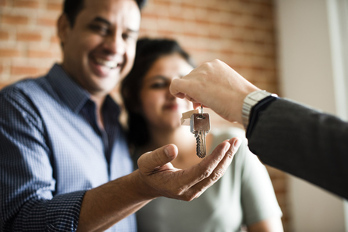 6 Signs an Applicant Will Make an Awesome Tenant for Your Rental Cheerful couple receiving keys to their new home