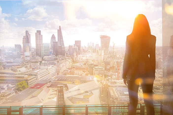 Why Today Is the Best Time to Invest in Real Estate Young woman looking over the City of London at sun set.