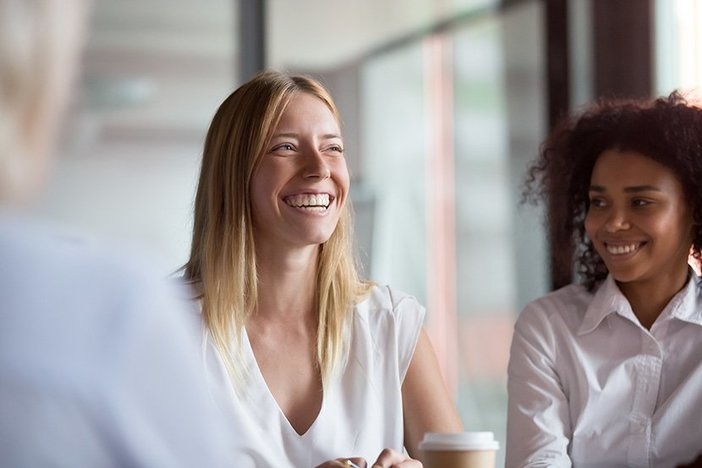 3 Surefire Ways To Win Over a Mentor Happy young businesswoman coach mentor leader laughing at funny joke at group business meeting, joyful smiling millennial lady having fun with diverse corporate team people engaged in talking at work