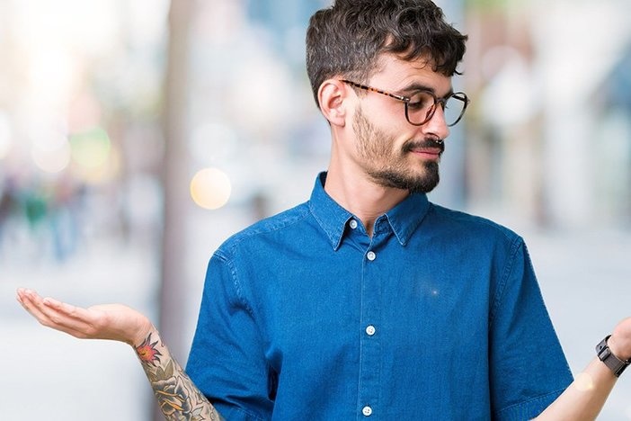 LLC vs. S Corporation: Which Is Better for Real Estate? Young handsome man wearing glasses over isolated background Smiling showing both hands open palms, presenting and advertising comparison and balance