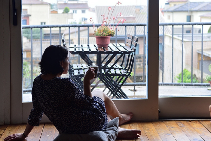 How Much Should You Save for Retirement? sad woman sitting and looking out the window