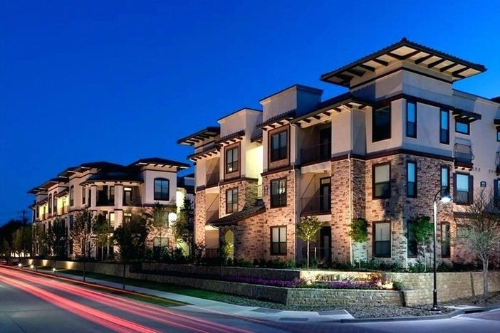 This Is the Sweet Spot for Breaking Into Multifamily Investing nighttime shot of upscale apartment building