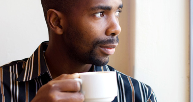 Becoming a Real Estate Agent: Is It the Right Choice for You? african american man drinking coffee looking out a window