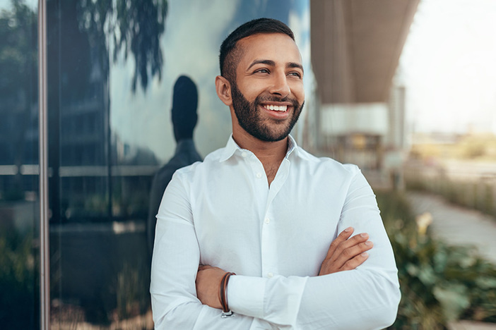 Premium Property Management Really IS Worth It: Here’s What It Can Do For You Portrait of a young confident smiling indian man with his arms crossed looking into the distance