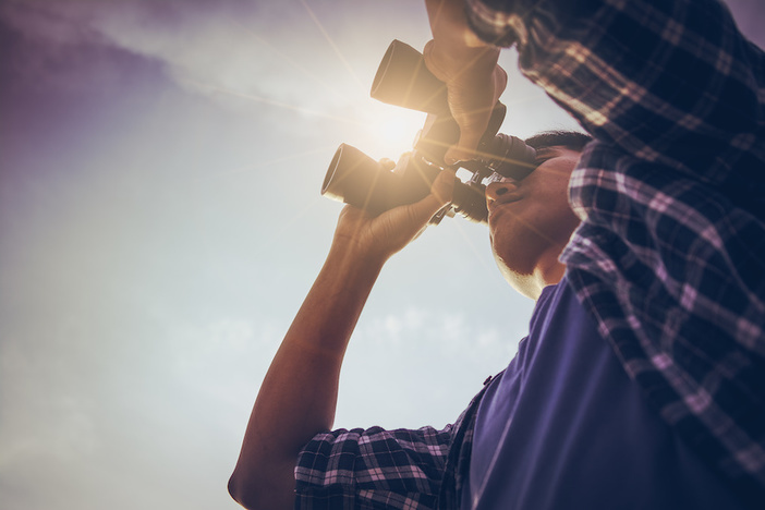Why You Should Stop Looking for an “Investor-Friendly” Real Estate Agent Close-up Of Asian man Hand Holding / looking / watching using Binoculars with copyspace, Technology Binoculars background concept