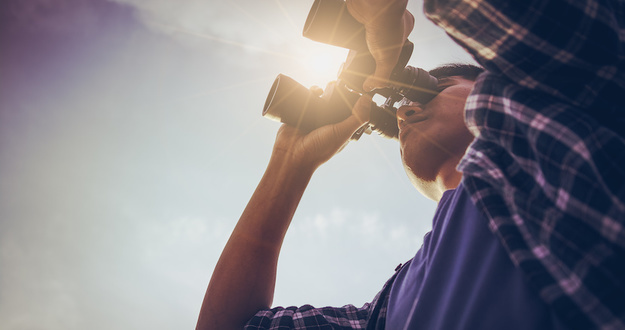 Why You Should Stop Looking for an “Investor-Friendly” Real Estate Agent Close-up Of Asian man Hand Holding / looking / watching using Binoculars with copyspace, Technology Binoculars background concept