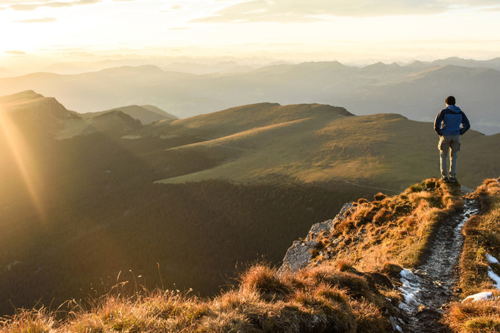 Beyond Cash Flow: How I Used Investing to Buy Real Estate in My “Happy Place” Silhouette of the man on top the peak of mountain on sunrise sky , Sport and active life conceptual design.
