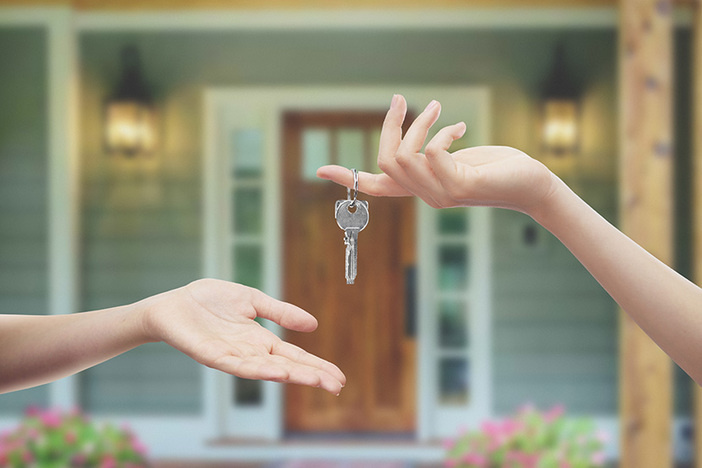 Choosing Between Turnkey & DIY Rentals? This is a MUST-Read Before You Decide! closeup of human hand with key dropping key into another person's open palm in front of a house